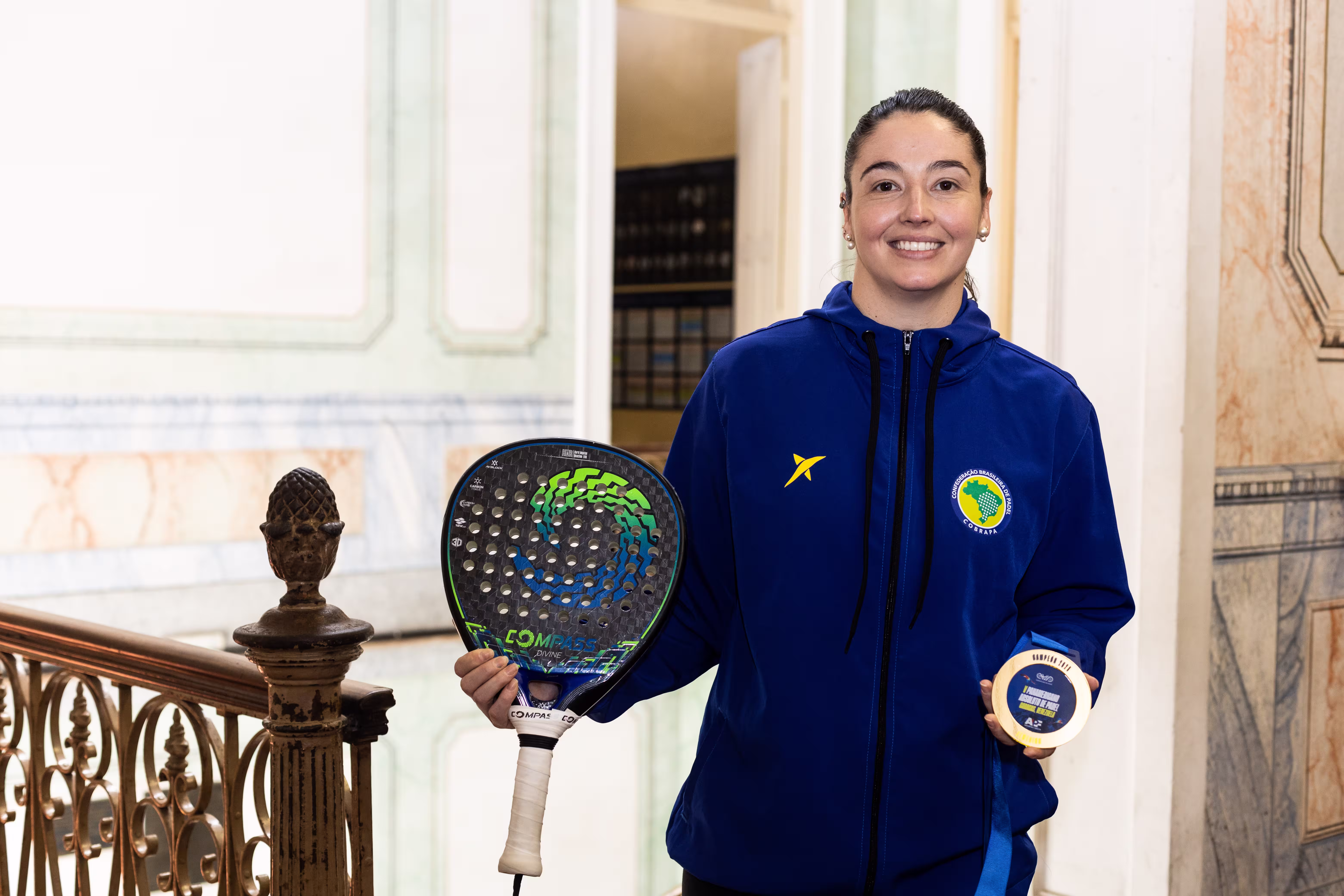 Padel player holding a medal and racket
